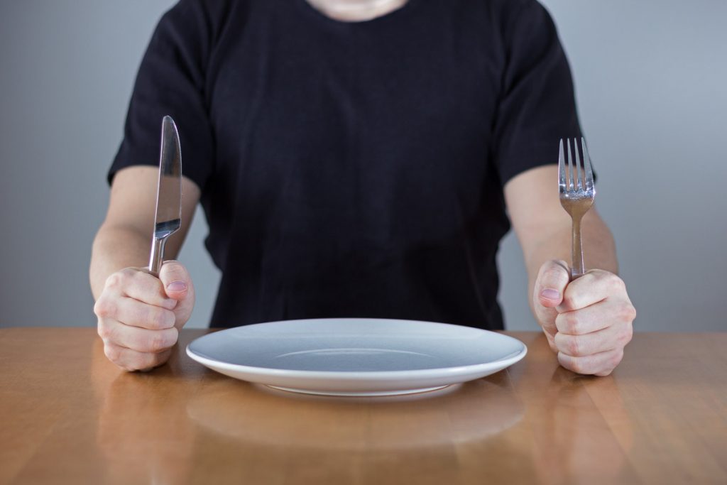 man waiting with an empty plate